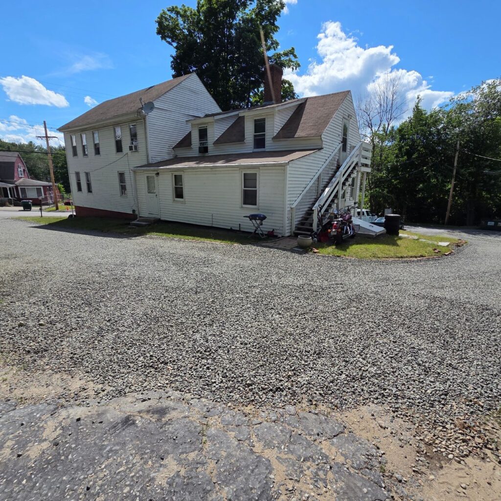 Property grading and gravel driveway installation surrounding a residential home.