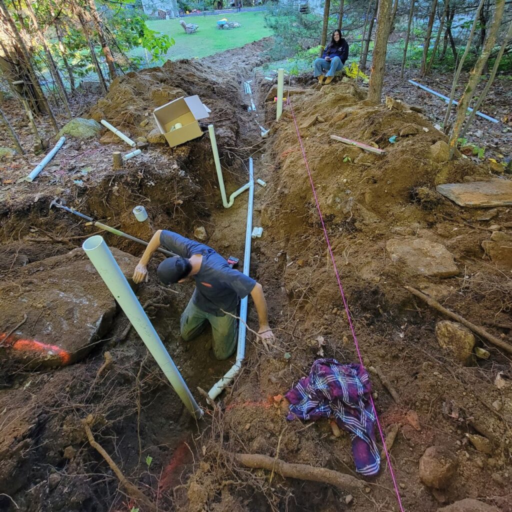 Drainage and grading work with drain piping set in an open trench in Central Massachusetts