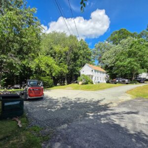 Gravel driveway resurfacing with fresh stone spread and graded over an existing drive in Central Massachusetts