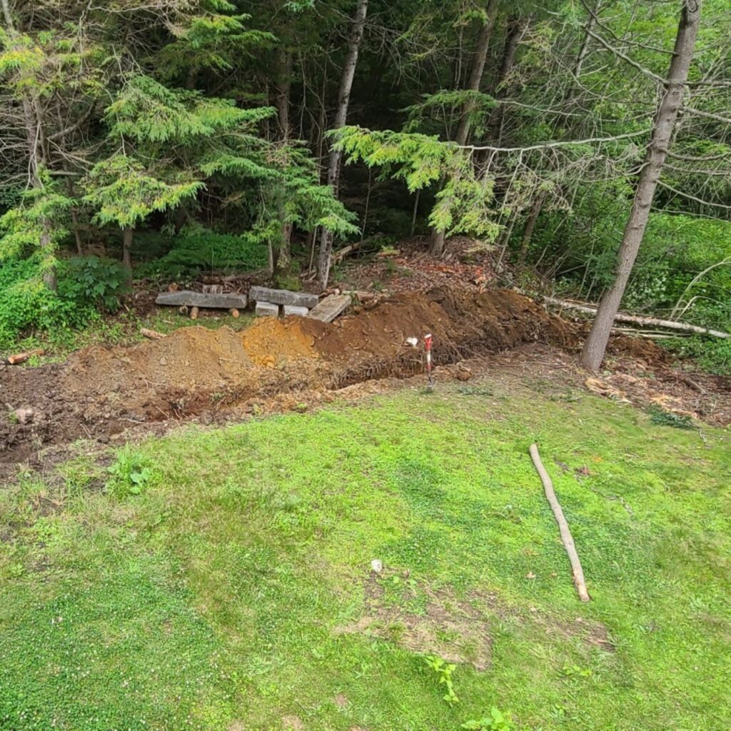 Runoff management shaping at the base of a wooded slope on a Central Massachusetts property
