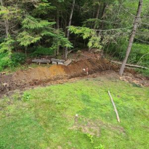Runoff management shaping at the base of a wooded slope on a Central Massachusetts property